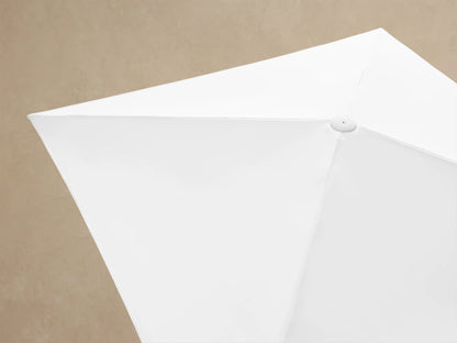Collapsed Nata 79" Outdoor Square Umbrella, white fabric canopy with visible folds, secured by a white strap and dark fastener.
