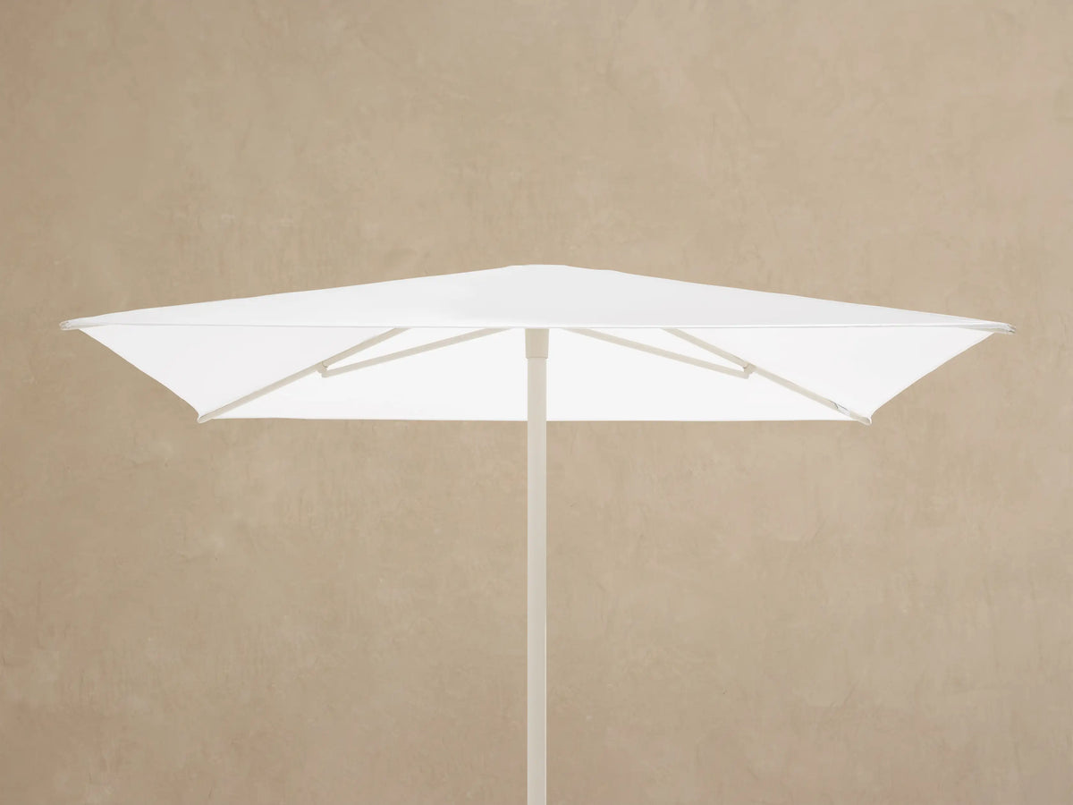 Close-up of Nata 79" Outdoor Square Umbrella's light beige central pole and ribs, seen from below against a white canopy.