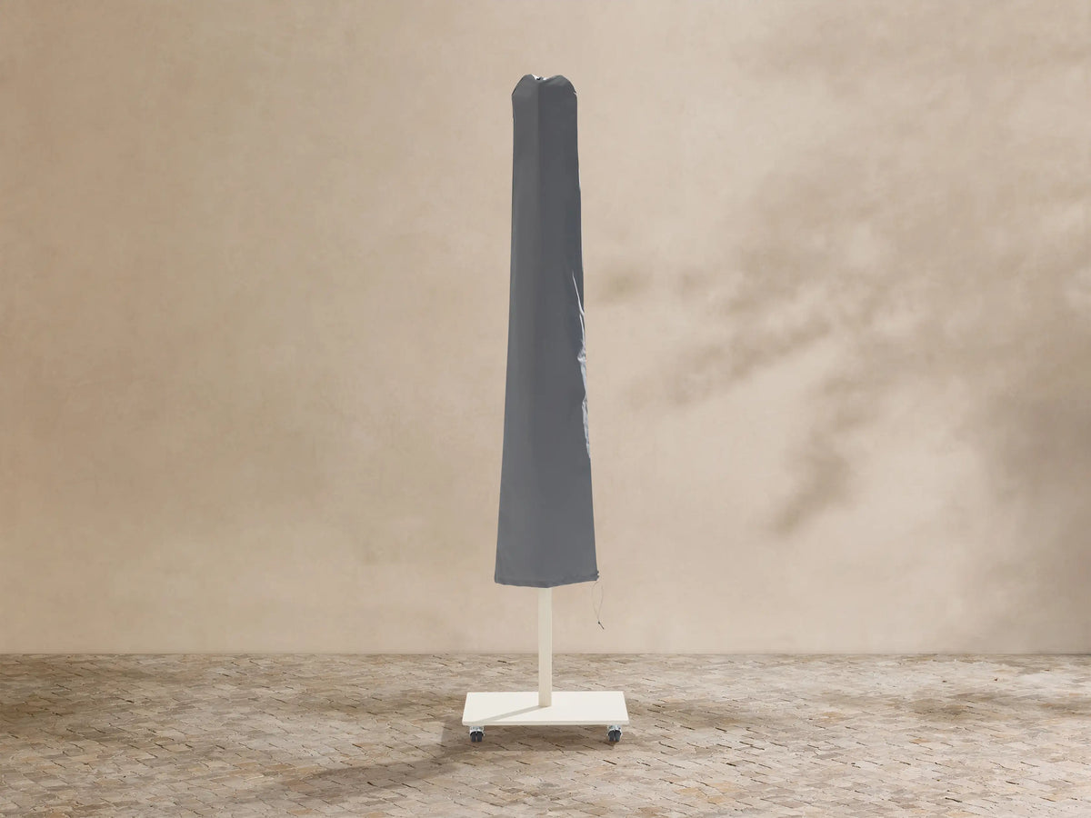 White Nata 79" Outdoor Square Umbrella, fully open, centered against a beige textured wall.