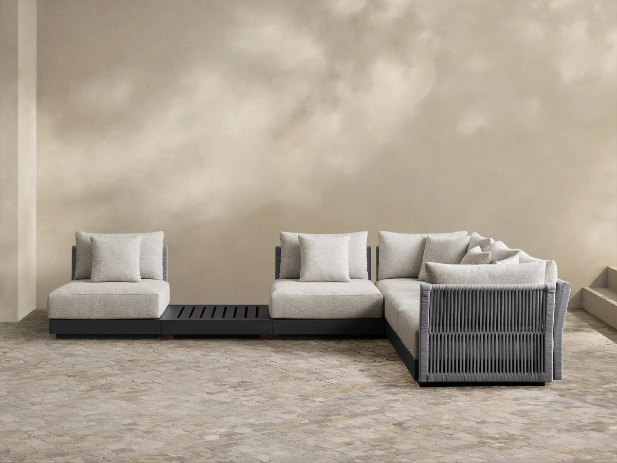 Naxos Outdoor Six-Piece Sectional: L-shaped light grey outdoor sectional with dark grey woven details, single chair, and slatted table.