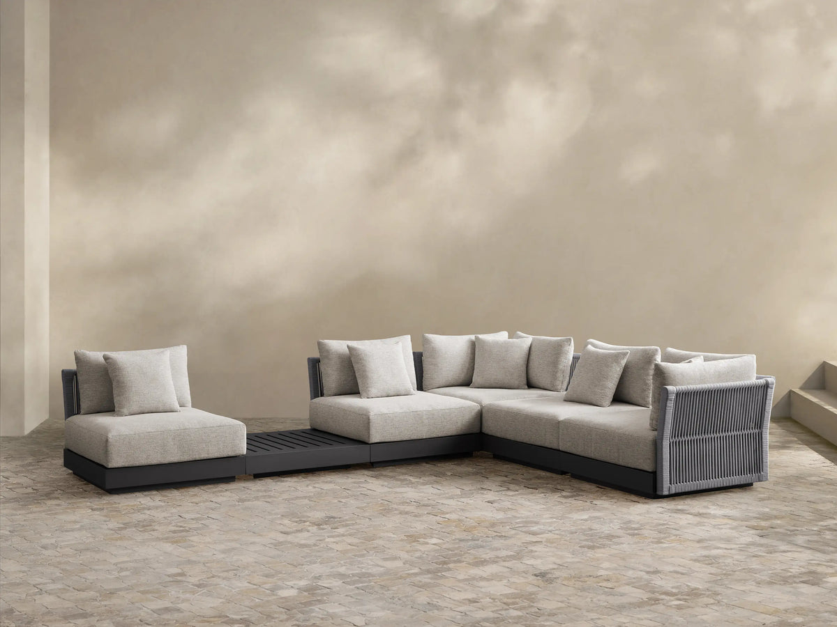 Naxos Outdoor Six-Piece Sectional: L-shaped light grey outdoor sectional with dark grey woven details, single chair, and slatted table.