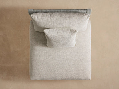 Naxos Outdoor Armless Chair, angled back view. Features light gray woven cording back, light beige cushions, dark gray base.