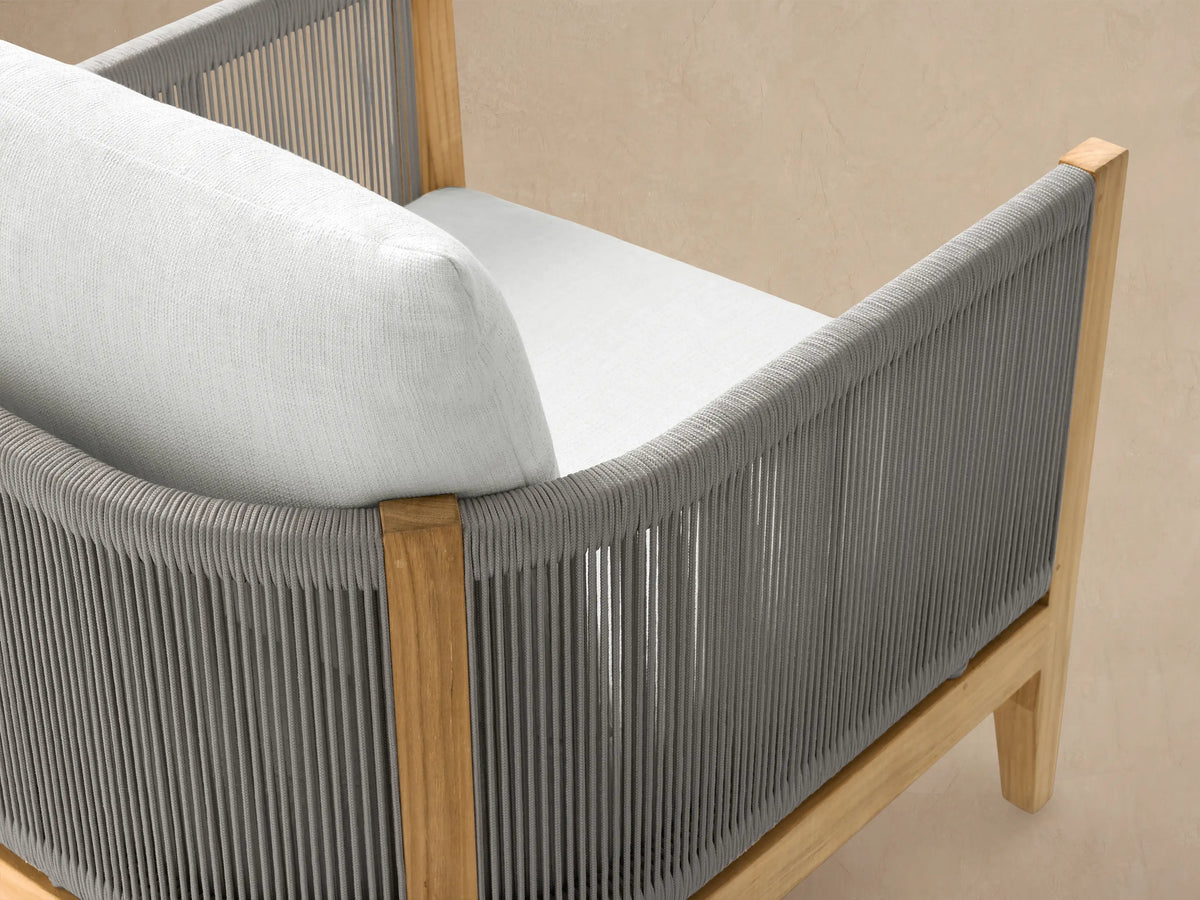 Newport Outdoor Lounge Chair in Eden Snow, front view. Light brown teak frame with woven gray sides and thick white cushions.