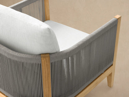 Newport Outdoor Lounge Chair in Eden Snow, front view. Light brown teak frame with woven gray sides and thick white cushions.