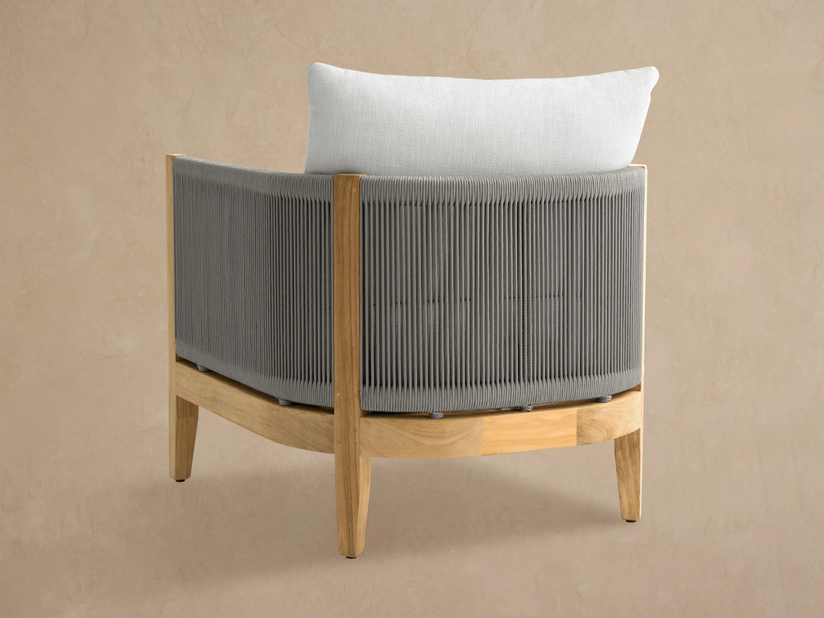 Newport Outdoor Lounge Chair, angled. Grey woven rope sides & back, natural teak frame, and plush white cushions.