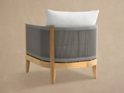Newport Outdoor Lounge Chair, angled. Grey woven rope sides & back, natural teak frame, and plush white cushions.