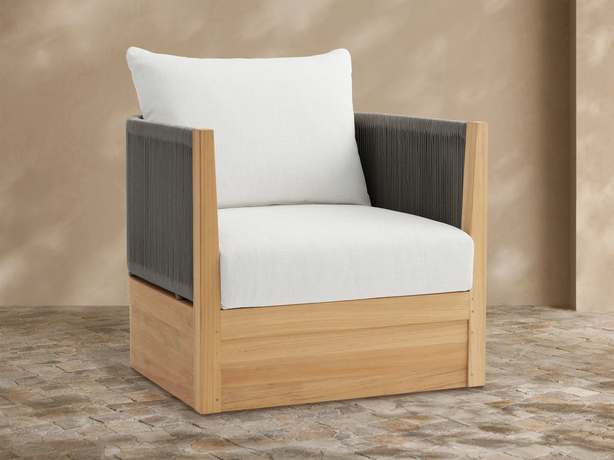 Newport Outdoor Swivel Chair with natural teak frame, dark grey rope arms, and white cushions on a tiled patio.