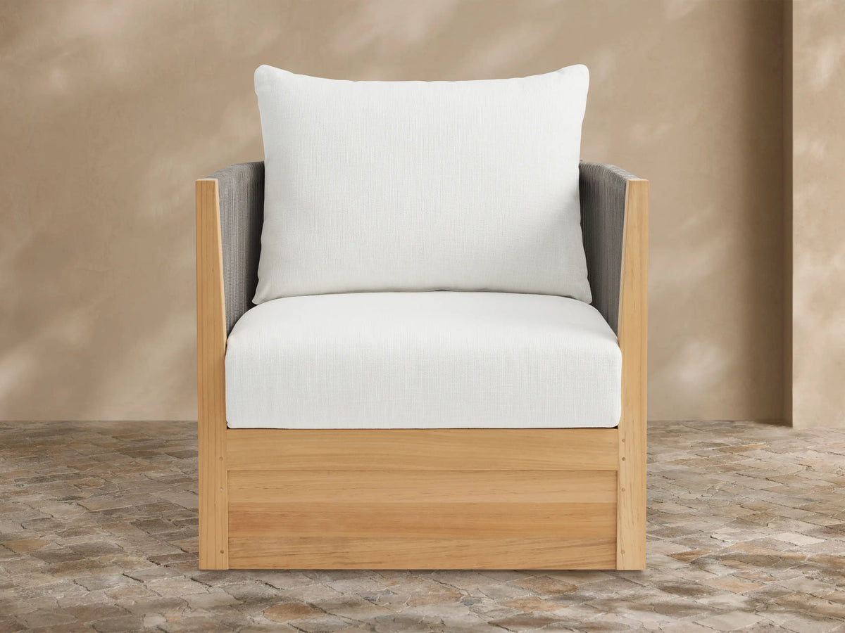 Newport Outdoor Swivel Chair with natural teak frame, dark grey rope arms, and white cushions on a tiled patio.
