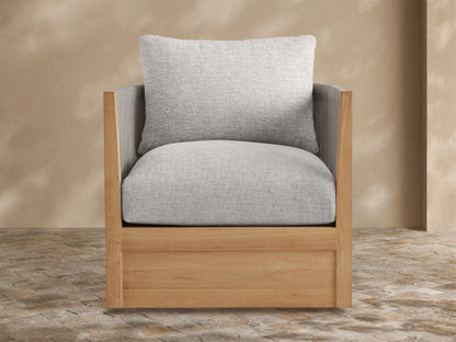 Newport Outdoor Lounge Chair with golden teak wood frame, woven gray rope arms/back, and plush light gray cushions, angled on a patio.
