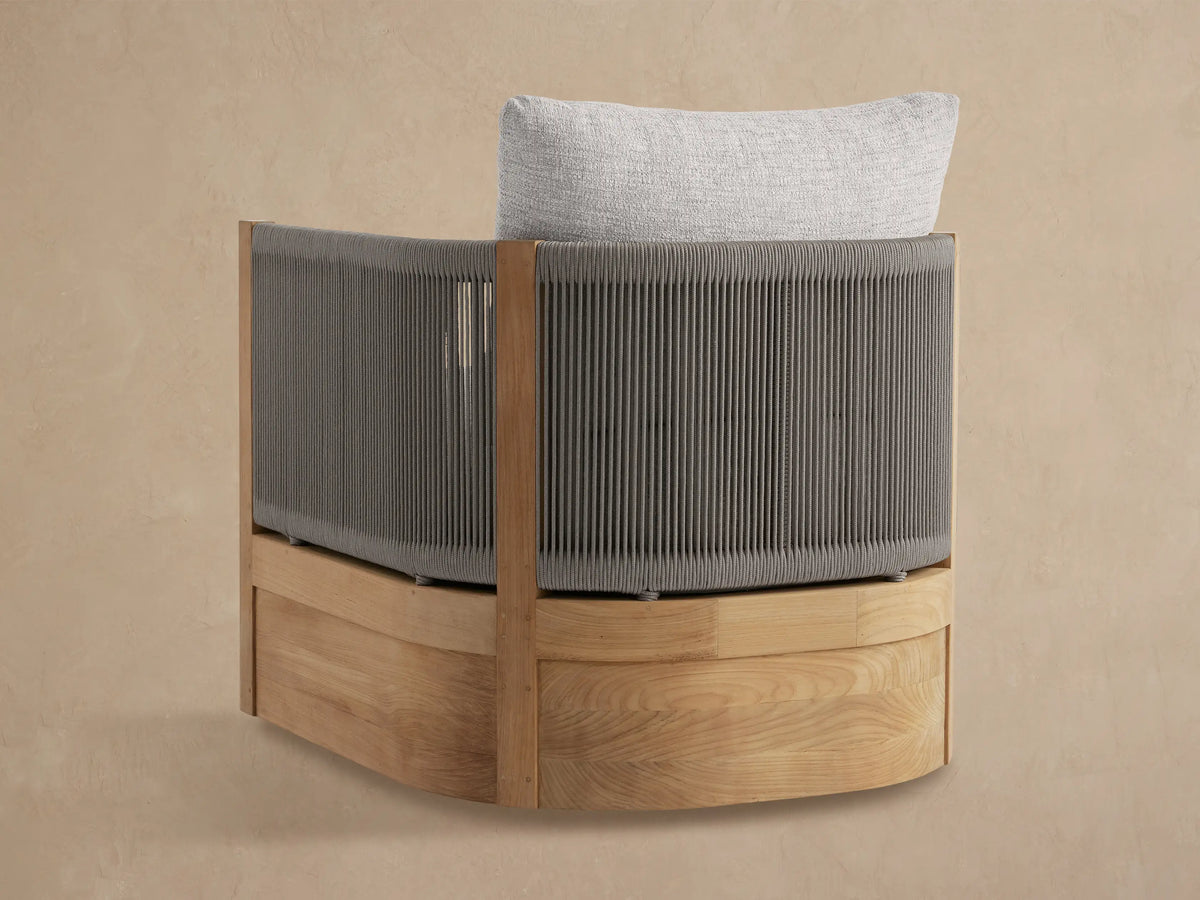 Close-up of Newport Outdoor Lounge Chair with grey woven rope frame, light teak accents, and textured light grey cushions.