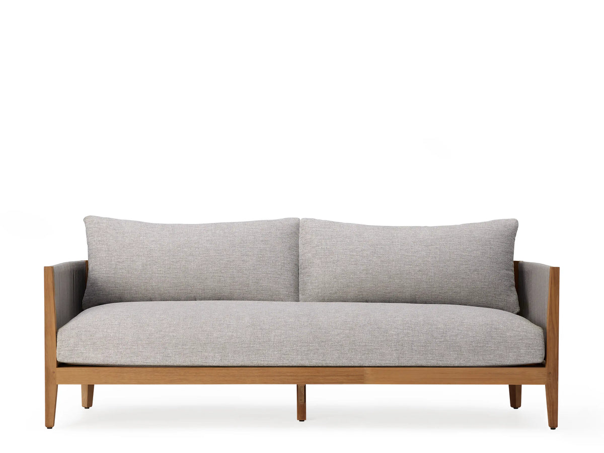 Side view of the Newport Outdoor Sofa showcasing a handwoven grey polyester rope frame on natural teak wood, with a plush grey cushion.