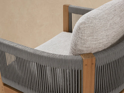 Newport Outdoor Dining Arm Chair, Shardai Zinc. Natural teak frame, gray rope armrests, light gray textured seat & back cushions, on mosaic floor.