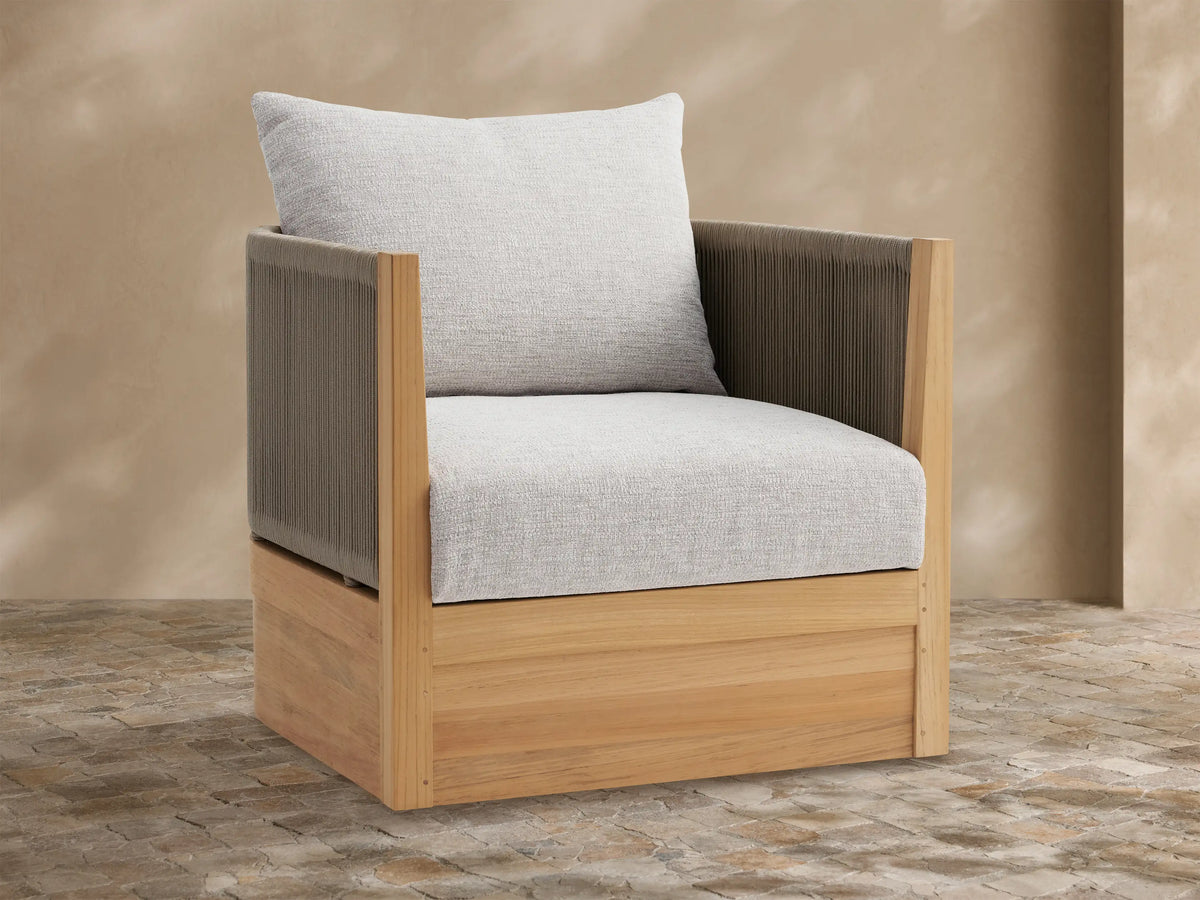 Newport Outdoor Lounge Chair with natural teak frame, dark brown woven sides, and light gray cushions, on a tiled patio.