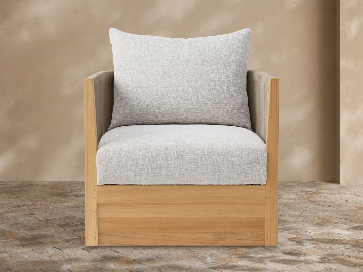 Newport Outdoor Lounge Chair with natural teak frame, dark brown woven sides, and light gray cushions, on a tiled patio.