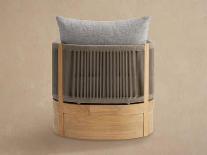 Close-up, angled view of Newport Outdoor Lounge Chair. Teak wood frame with taupe woven rope sides & light grey cushions.