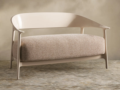 Front view of Nia Outdoor Sofa, light beige molded frame with a curved back. Speckled light brown outdoor cushion.
