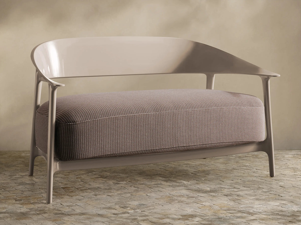 Nia Outdoor Sofa: Modern light greige frame, curved back, arms. Single large textured beige cushion, front view.