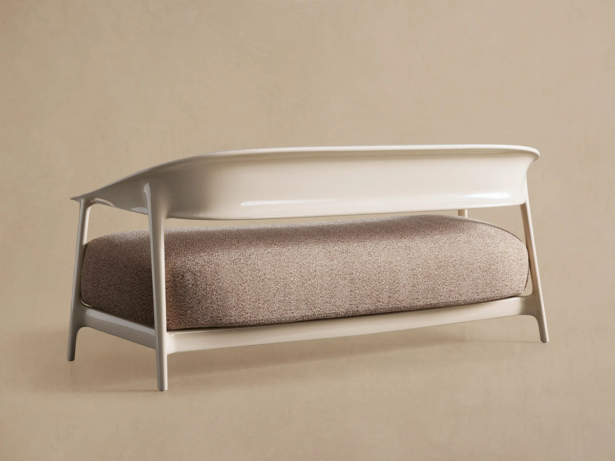 Nia Outdoor Sofa detail: textured brown cushion next to a smooth, curved off-white armrest and frame.