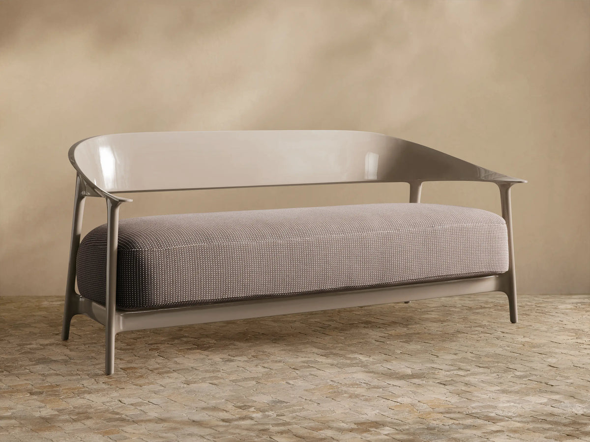 Nia Outdoor Sofa, light taupe, front view. Sleek, glossy curved frame with a textured gray-brown patterned cushion.