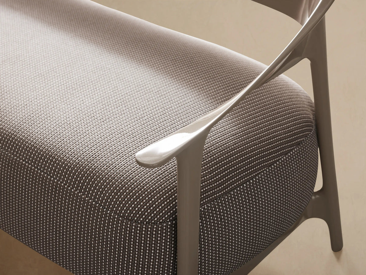 Modern Nia Outdoor Sofa, light taupe curved frame, textured light grey cushions, angled right on a tiled floor.