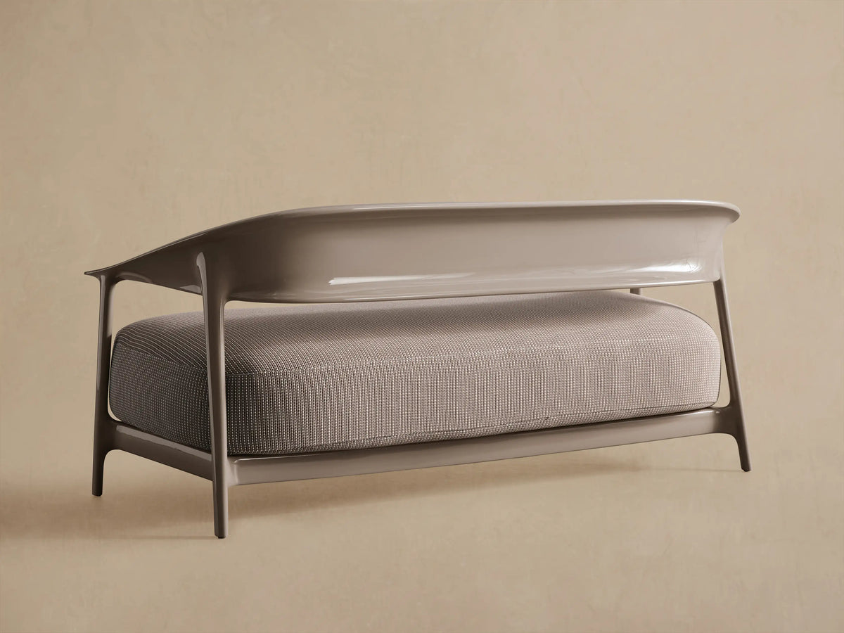 Close-up of Nia Outdoor Sofa. Textured gray fabric with white dotted weave, smooth modern curved light grey armrest.