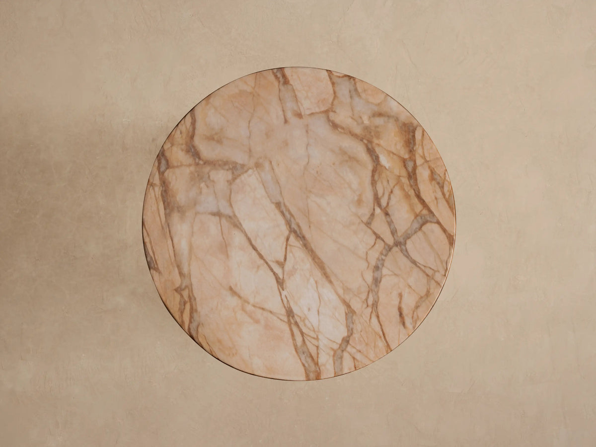 Close-up of Odessa Outdoor End Table, round light brown top & thick support with dark brown stone-like veining.