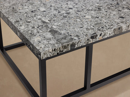 Paloma Outdoor Coffee Table with light gray speckled sintered stone top on a black rectangular metal frame, against a textured tan wall.