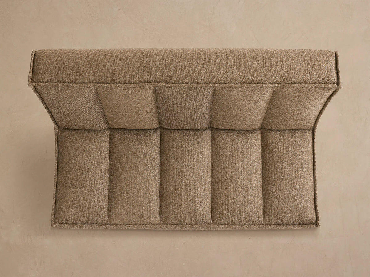Back view of Porto armless sofa in dark beige fabric with channel stitching