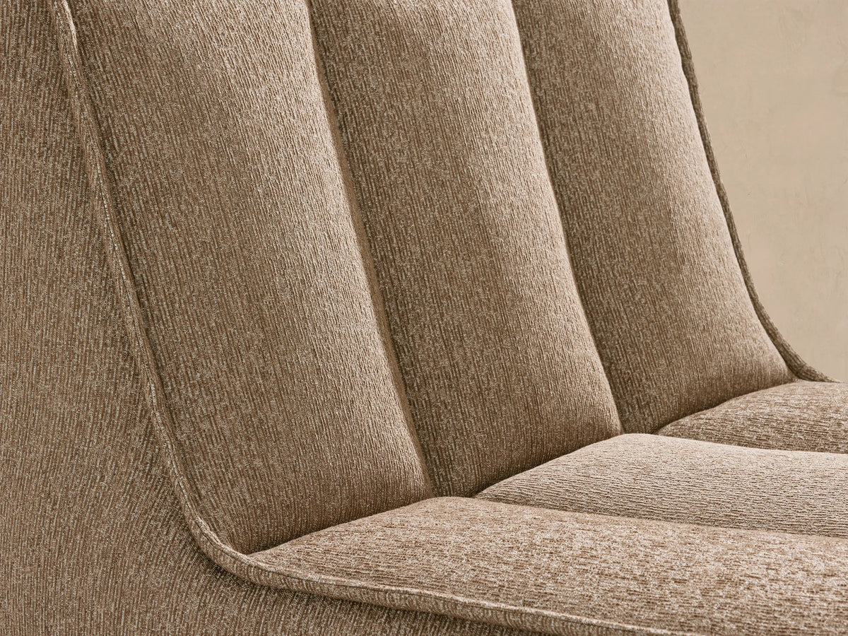 Side view of Porto armless chaise in dark beige fabric with channel stitching