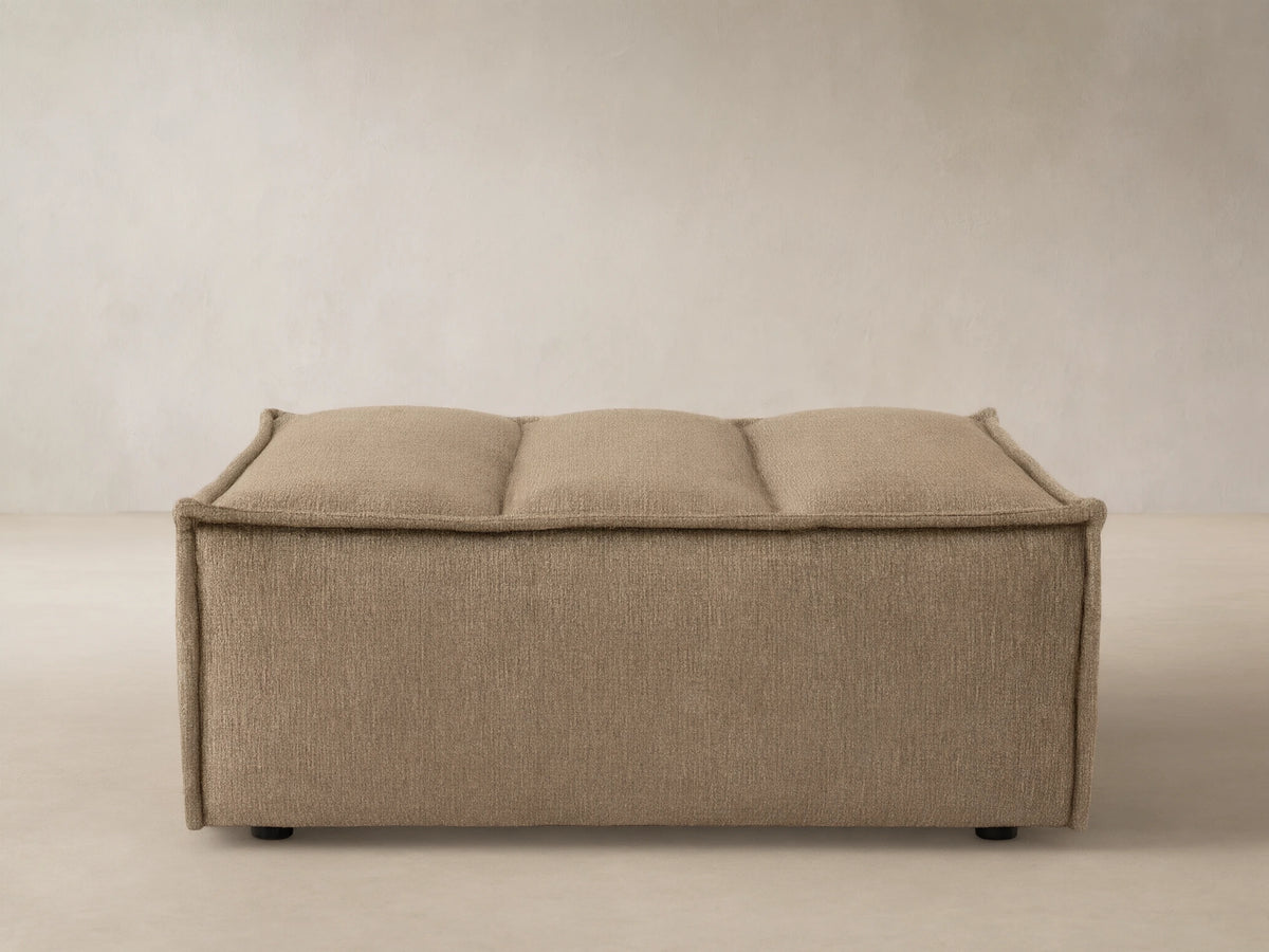 Porto ottoman in dark beige fabric with channel stitching