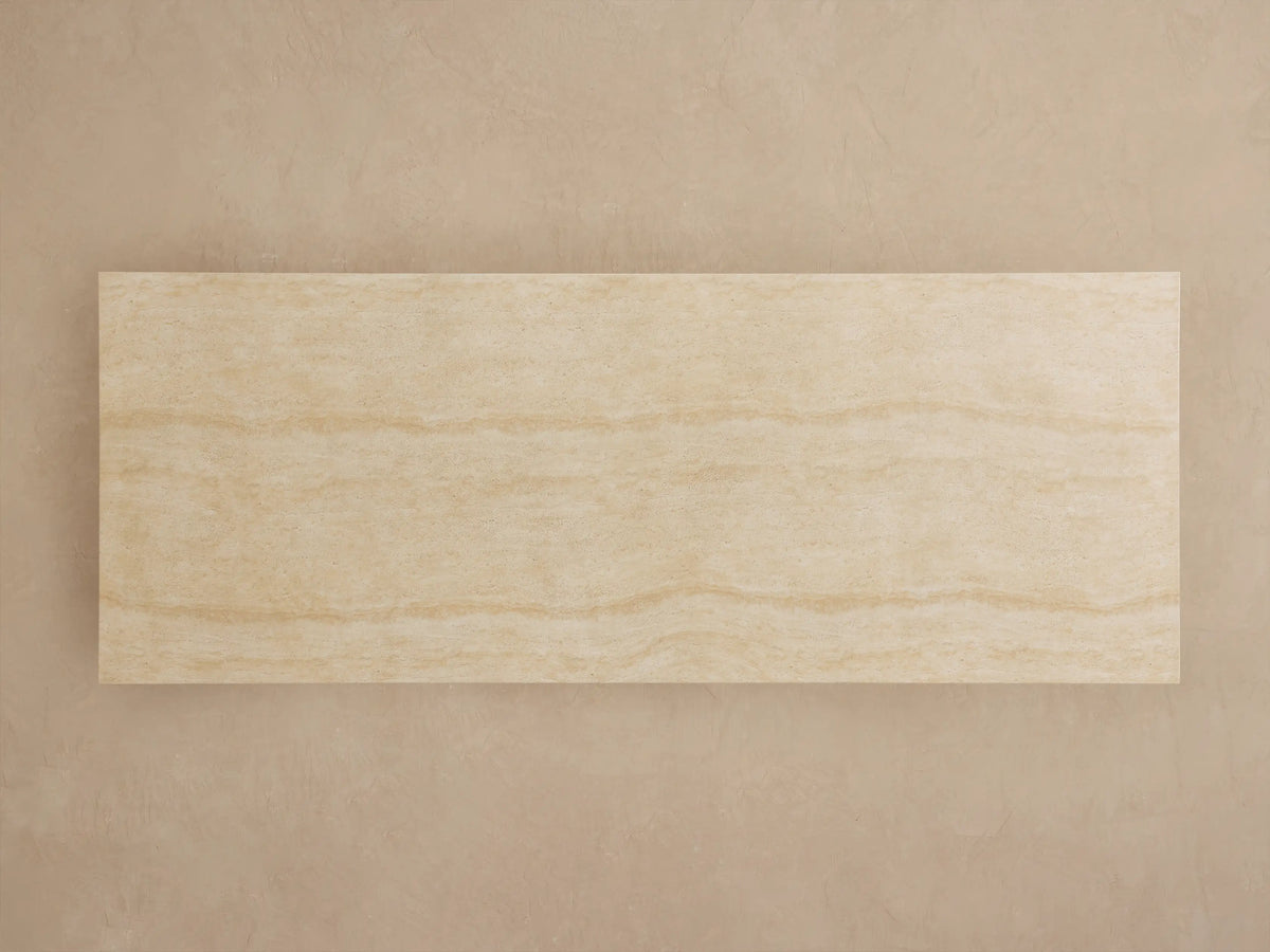 Close-up of Primrose Outdoor Dining Table. Light beige, textured concrete surface and part of its sculpted pedestal base.