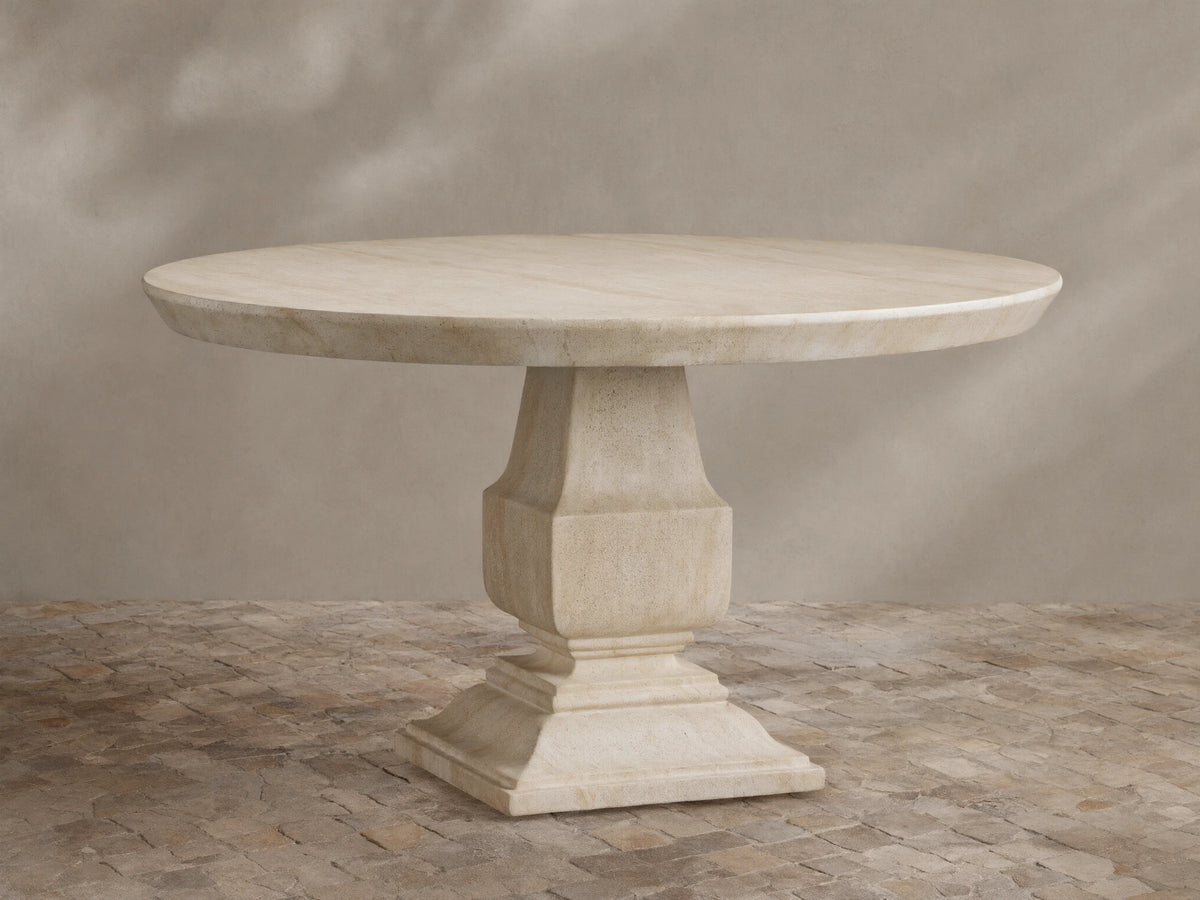 Primrose Outdoor Round Dining Table in light beige GFRC, round top with subtle grey veining, on a sculpted pedestal base, on tiles.