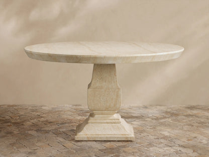 Primrose Outdoor Round Dining Table in light beige GFRC, round top with subtle grey veining, on a sculpted pedestal base, on tiles.