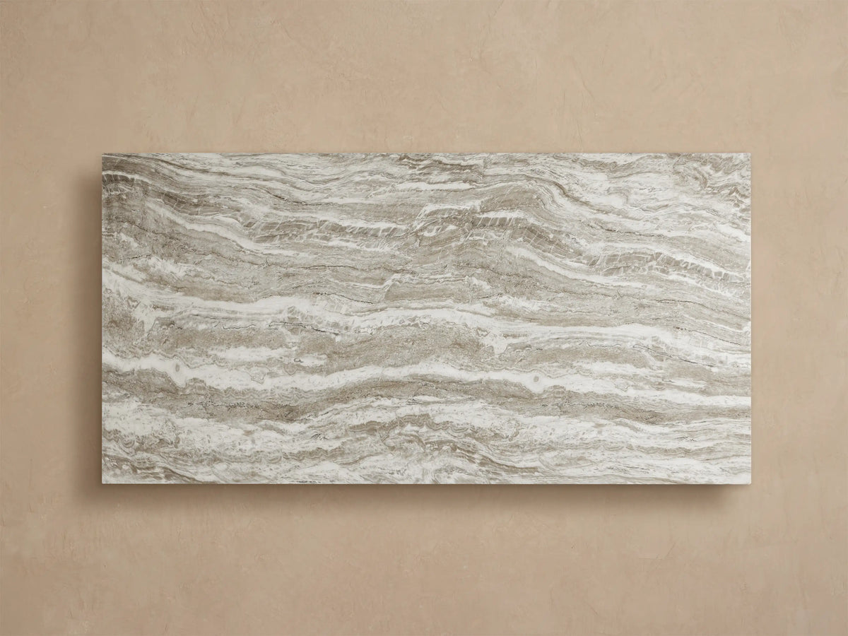 Close-up of Primrose Outdoor Dining Table showing its white, grey, and brown veined natural stone-look top and sculpted base.