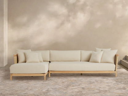 Puglia Outdoor Teak Two-Piece Sectional with Chaise, light teak L-shaped frame, cream cushions & toss pillows, woven accents.