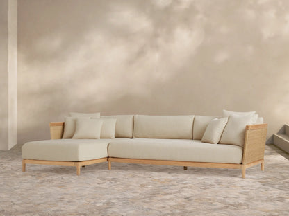 Puglia Outdoor Teak Two-Piece Sectional with Chaise, light teak L-shaped frame, cream cushions & toss pillows, woven accents.