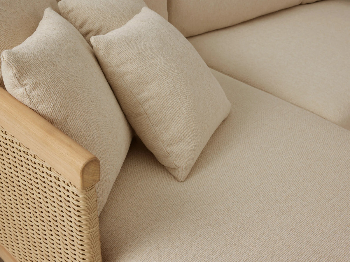 Puglia Outdoor Teak Two-Piece Sectional with Chaise, light teak frame, woven resin wicker arms, cream cushions, on patio.