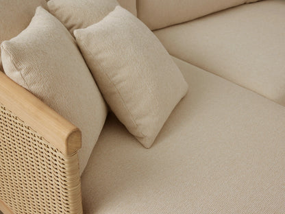 Puglia Outdoor Teak Two-Piece Sectional with Chaise, light teak frame, woven resin wicker arms, cream cushions, on patio.
