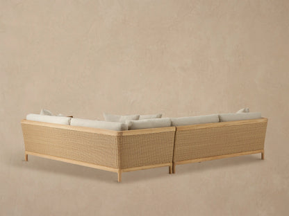 Puglia Outdoor Teak Sectional armrest in natural teak and woven wicker, with light beige textured cushions.