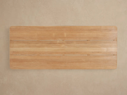 Close-up angled view of Puglia Outdoor Teak Coffee Table, showing light blonde slatted top with natural wood grain and rounded edges.