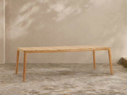Puglia Outdoor Teak Dining Table, long rectangular light natural teak wood table with slatted top and sturdy legs.