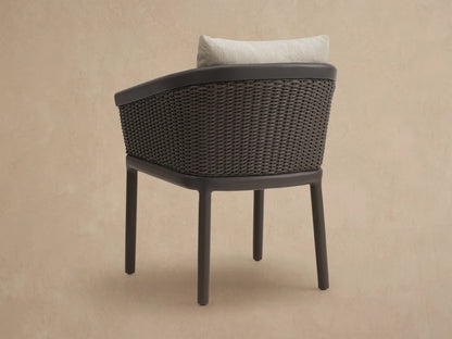 Angled close-up of Puglia Outdoor Aluminum Dining Chair: brown frame, dark brown woven wicker, and light beige textured cushions.