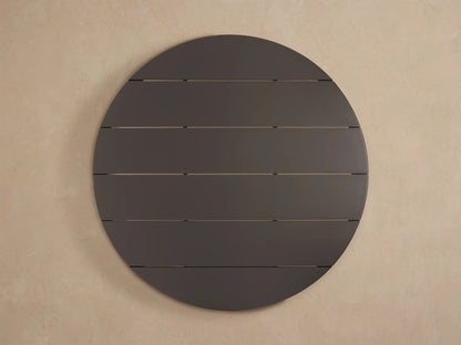Close-up of Puglia Outdoor Aluminum Round Dining Table. Dark gray matte slatted top with rounded edge and a leg, viewed from above.