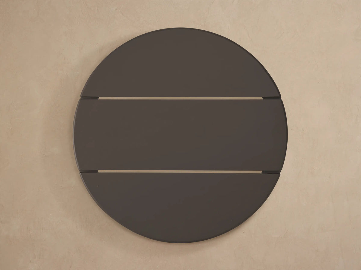 Close-up of a black, round Puglia Outdoor Aluminum End Table with a slatted, textured, powder-coated top.