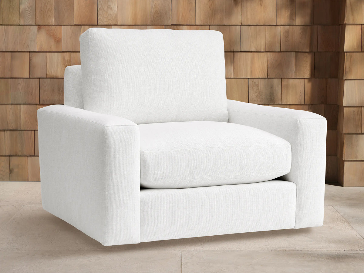 Remington Outdoor Swivel Chair in Eden Snow, a white modern outdoor swivel armchair with thick cushions & wide arms on light floor.