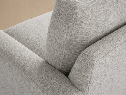 Remington Outdoor Sofa. Light gray fabric, 2-seat sofa with wide arms, against a textured wood shingle wall on a patio.