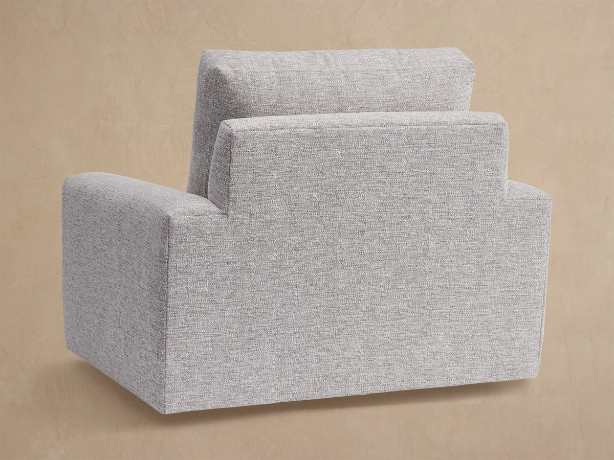 Light grey, heathered woven fabric on Remington Outdoor Swivel Chair's seat cushion & rectangular armrest, close-up, angled.