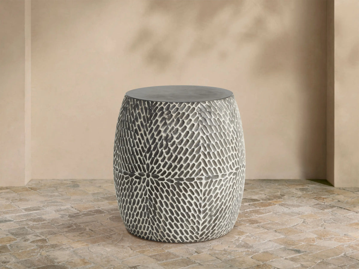 Roche Outdoor End Table, barrel-shaped, dark gray top, hand-textured sides with light gray organic pattern on patio.