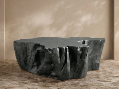 Dark gray Root Outdoor Coffee Table with an organic, textured shape and smooth top, on a light brown tiled floor.