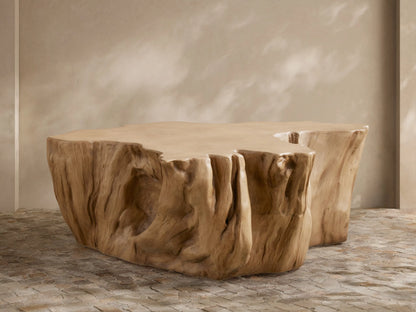 Root Outdoor Coffee Table, light brown concrete, sculpted like a tree root with textured sides, on a stone patio.